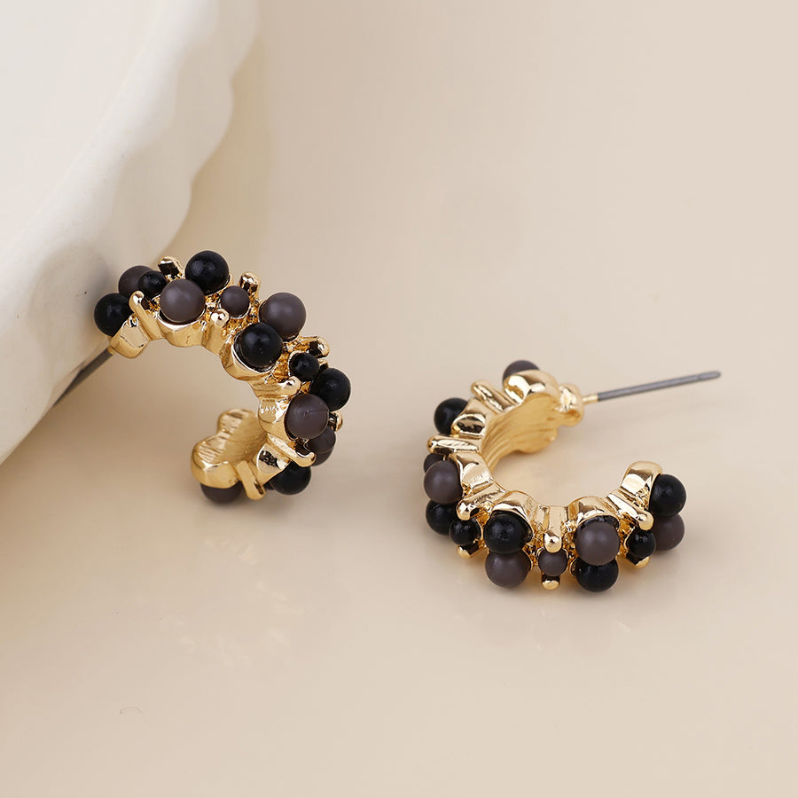 Clara golden cluster hoop earrings in black and gold